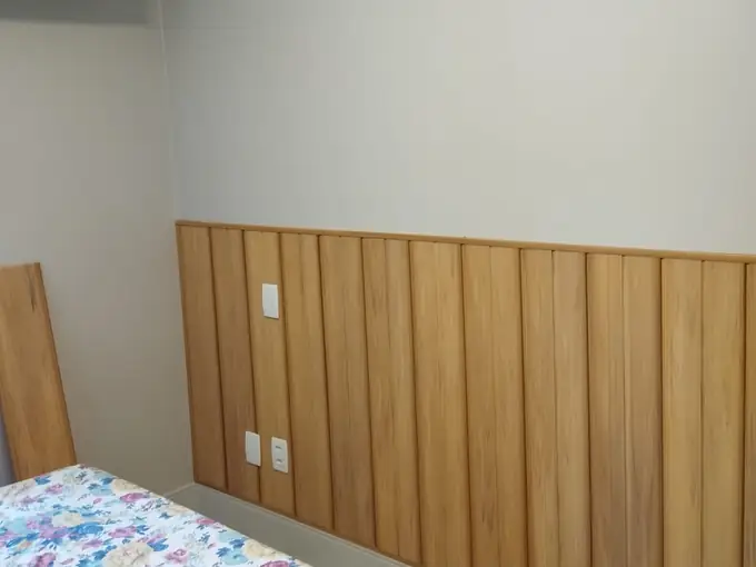 Quarto com meia-parede revestida em PVC amadeirado e rodapé de arremate